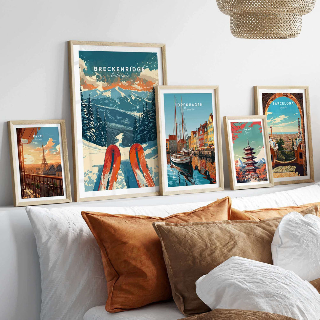 Framed Breckenridge Print and travel posters on a cozy bed, showcasing winter adventure and scenic landscapes.