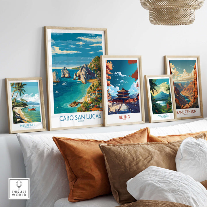 Colorful travel posters including Cabo San Lucas, displayed on a cozy couch with brown cushions and modern decor.