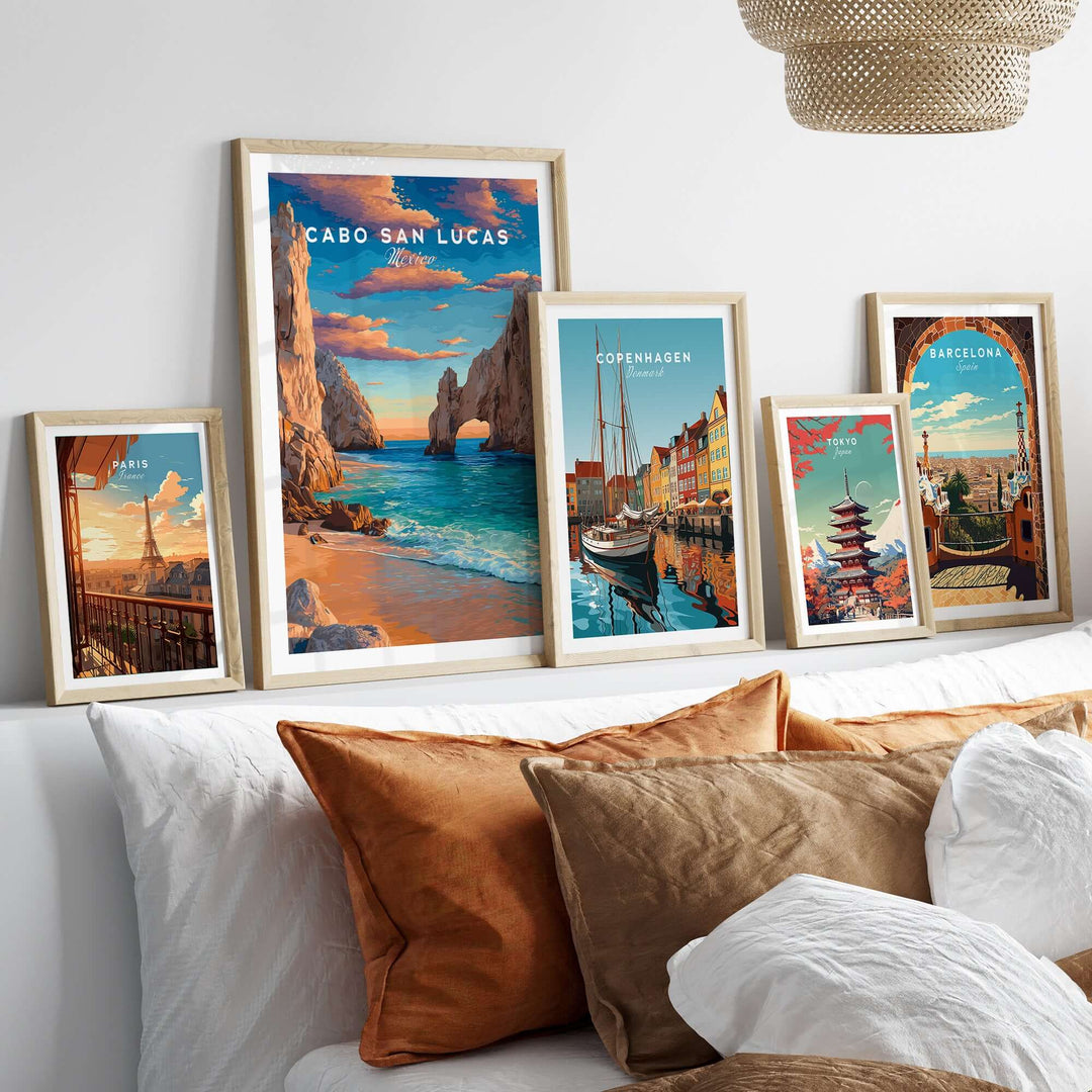 Cabo San Lucas sunset travel print poster among travel art prints displayed on a modern couch with decorative pillows.
