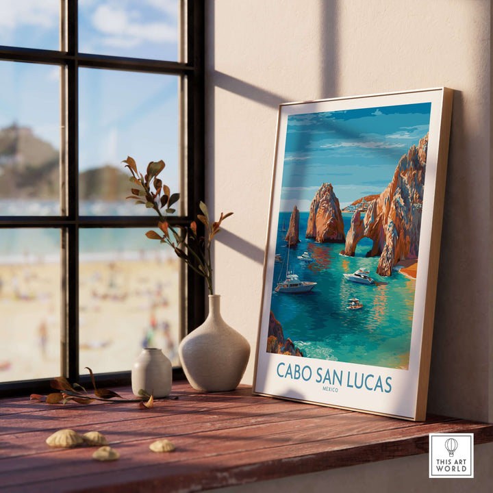 Cabo San Lucas travel poster featuring El Arco and boats in turquoise water, displayed in a sunny indoor setting.