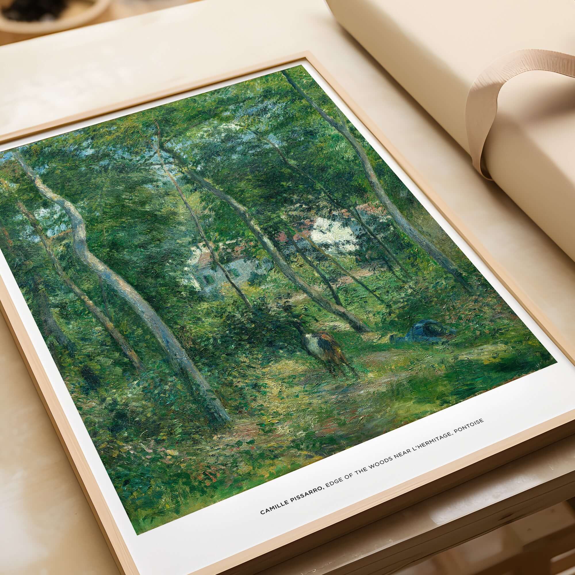 Exhibition Art Print Camille Pissarro Edge of the Woods Impressionist Landscape Poster Wall Art displayed on a table.