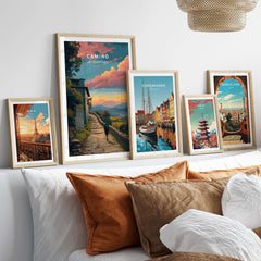Camino de Santiago Sunset Path Print | Hiking Wall Decor Gift displayed among various travel prints on a stylish bed.