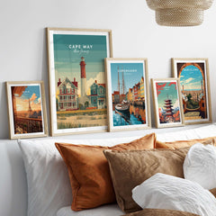 Cape May New Jersey Lighthouse Art Print - Victorian Houses Poster displayed in elegant frames on a shelf.