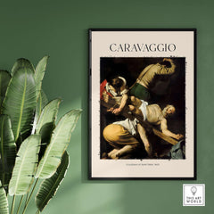 Caravaggio Art Print - Crucifixion of Saint Peter 1601 framed art piece on a green wall with indoor plants.