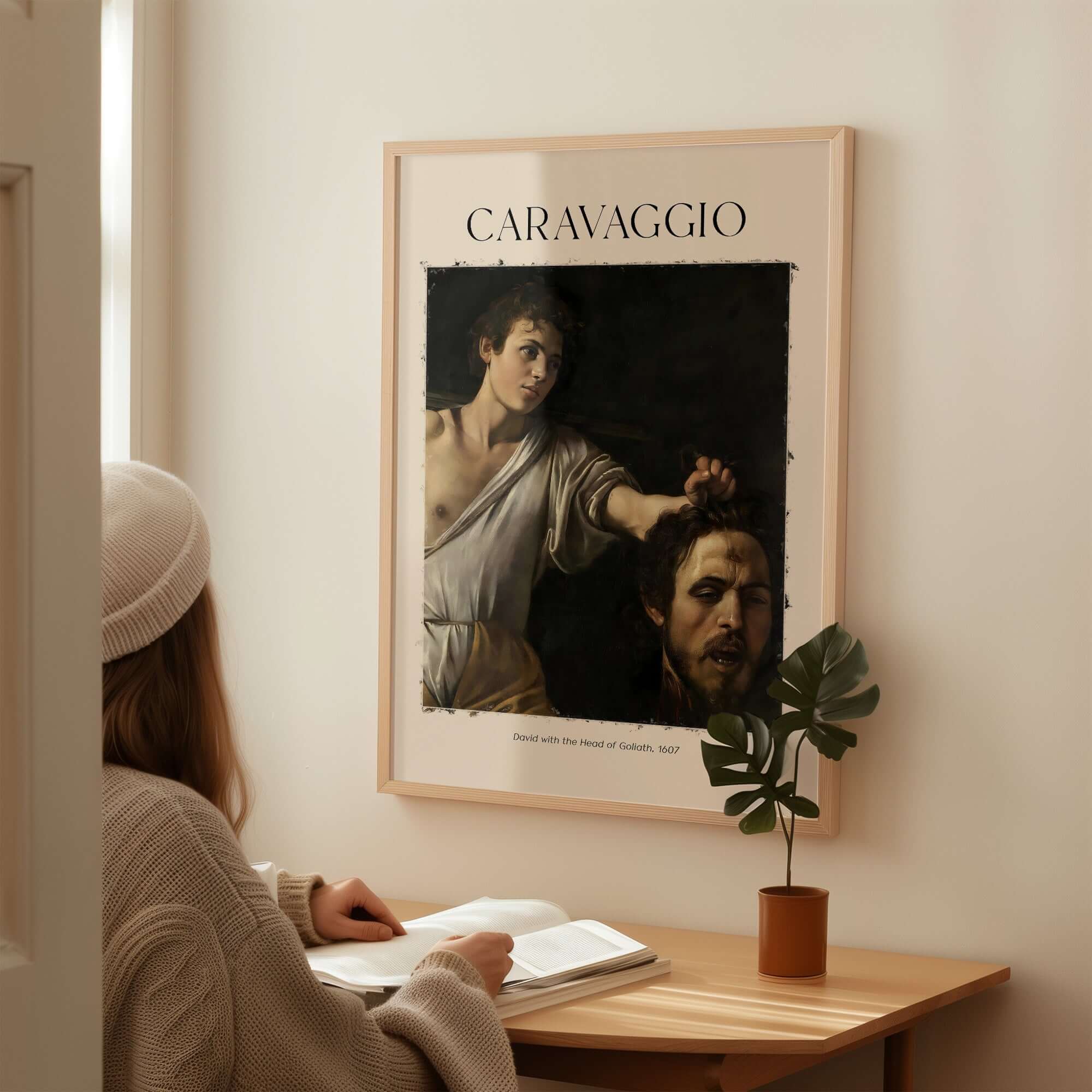 Caravaggio Art Print - David with the Head of Goliath Poster 1607 displayed on a wall with a person admiring it.