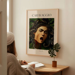 Caravaggio Art Prints - Medusa 1597 displayed in a modern room with a woman studying nearby.
