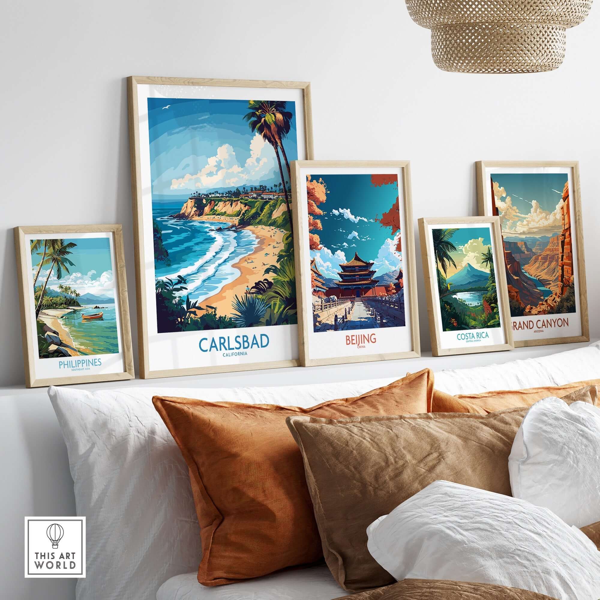 Carlsbad Poster California displayed among other travel posters on a cozy couch, showcasing vibrant coastal art.