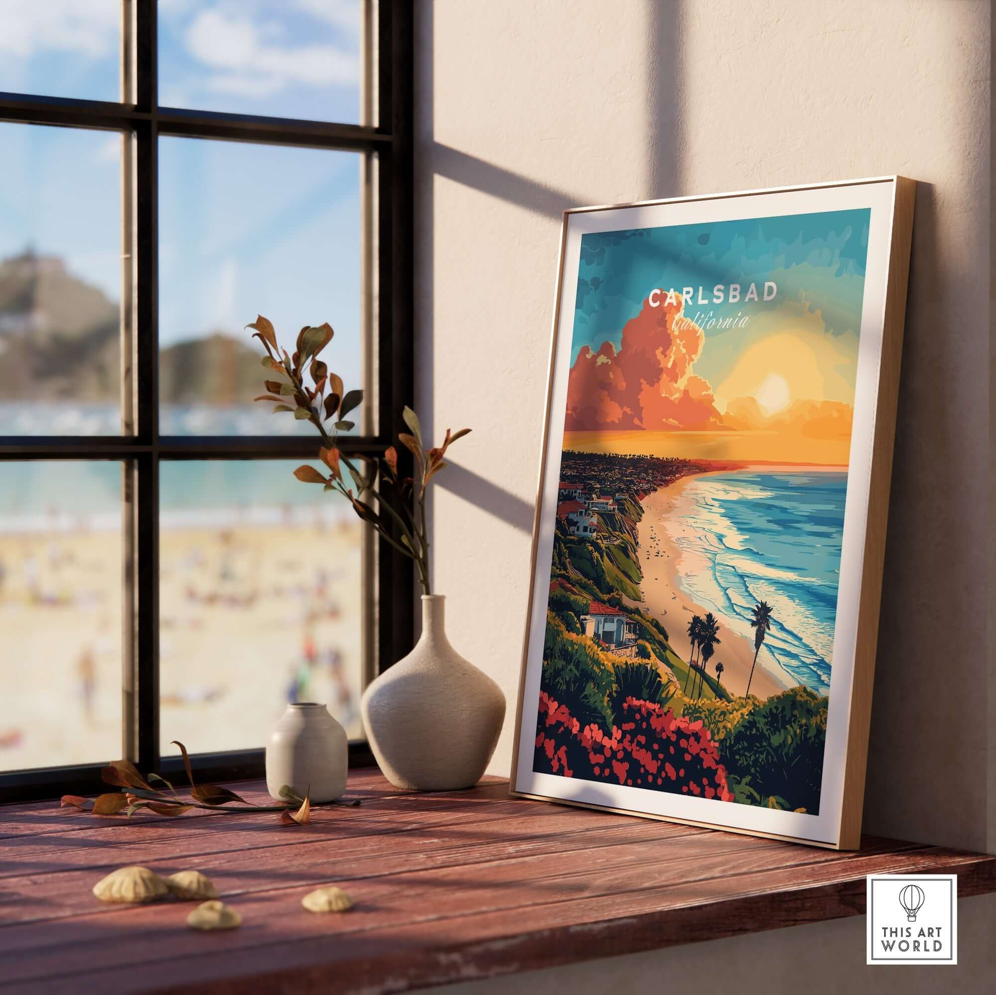 Carlsbad Travel Print displayed in a cozy setting with coastal view and vibrant sunset colors.