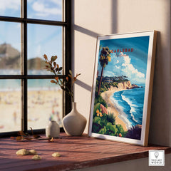 Carlsbad Wall Art framed on a windowsill overlooking the beach, featuring vibrant colors and coastal scenery.