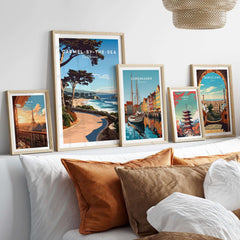 Carmel-by-the-Sea Poster Print displayed among other travel posters in a stylish, cozy home setting.