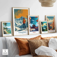 Collection of framed travel posters including Chamonix, Beijing, and Grand Canyon displayed above a sofa.