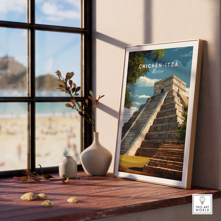 Chichén Itzá travel print featuring El Castillo pyramid poster displayed by a window with beach view.