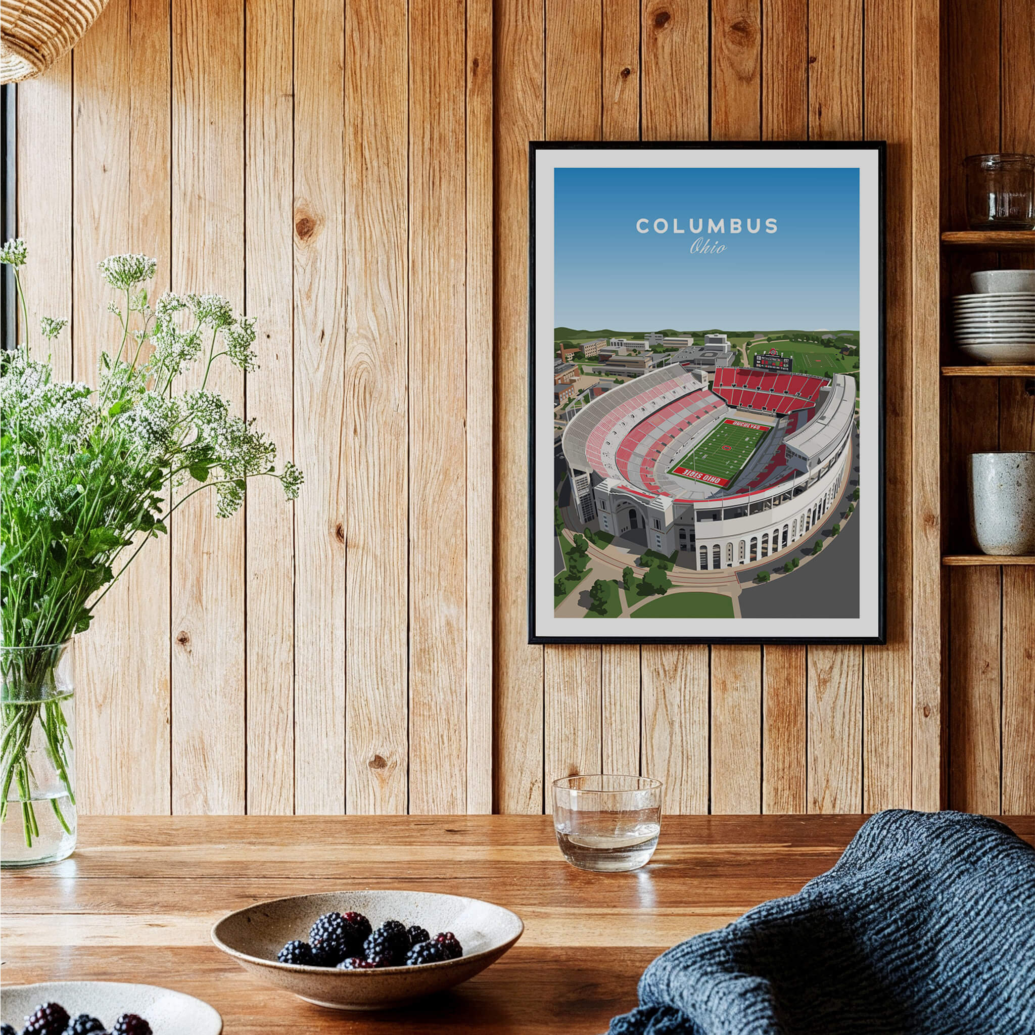 Columbus Ohio Travel Poster – Ohio State Stadium Art Print hanging in a wooden interior with flowers and a bowl of berries.