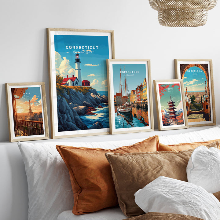 Connecticut poster with scenic landmarks in a framed collection, displayed above a cozy couch with travel prints.