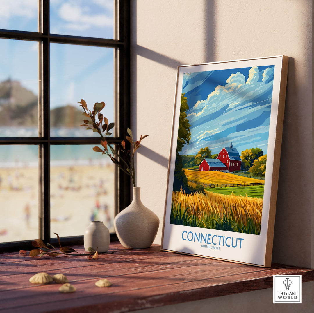 Connecticut Print featuring scenic landscape with red barn and wheat field, framed and displayed on a windowsill.