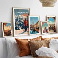 Copper Mountain Travel Poster – Skiing Into Sunset displayed among other travel posters on a stylish sofa.
