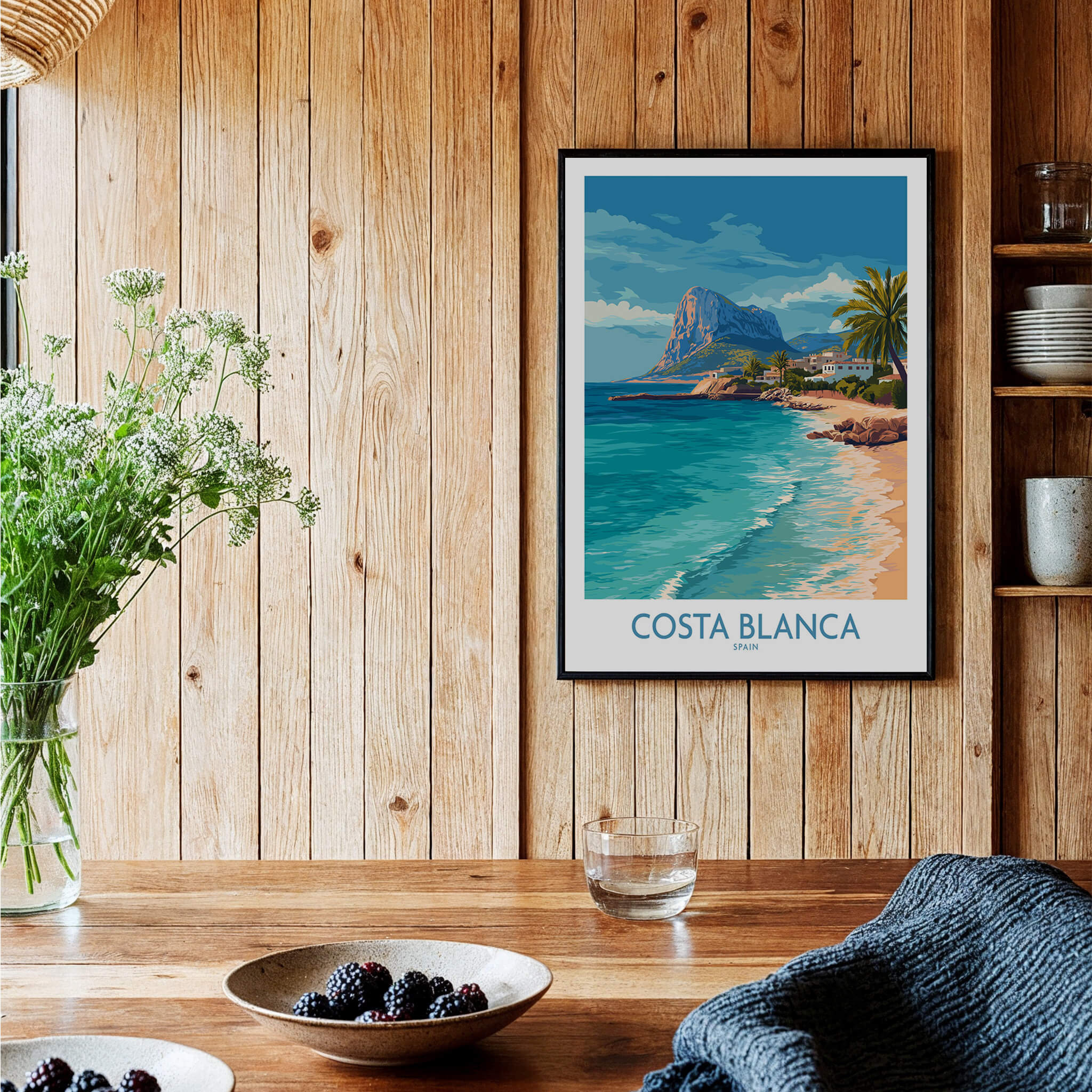 Costa Blanca Poster - Spain Wall Art displayed on wooden wall, showcasing coastal landscape and vibrant Mediterranean colors.