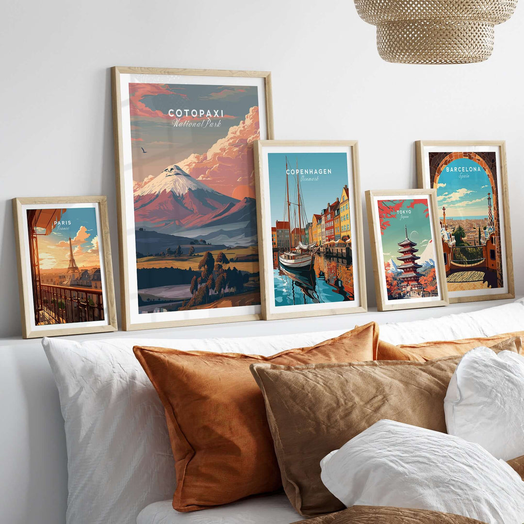 Framed travel posters of Cotopaxi, Copenhagen, and Barcelona above a stylish sofa with decorative pillows.