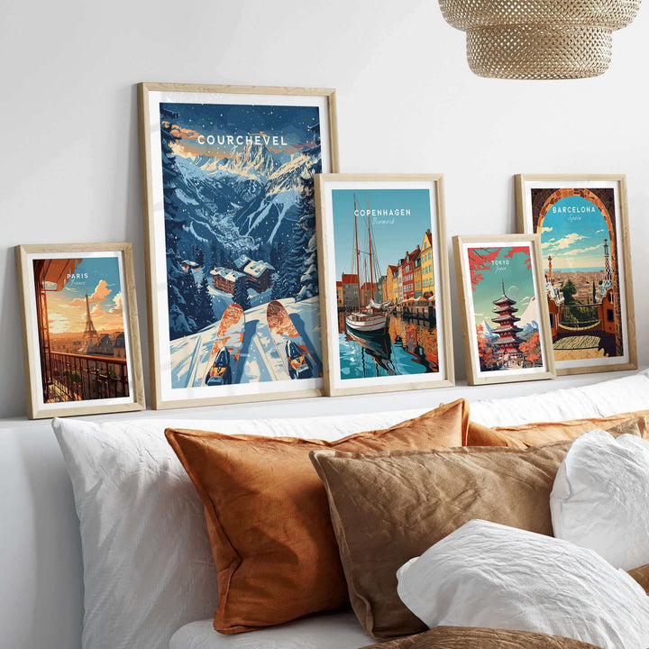 Collection of framed travel prints featuring Courchevel, France, and other cities displayed on a wall above a cozy bed.