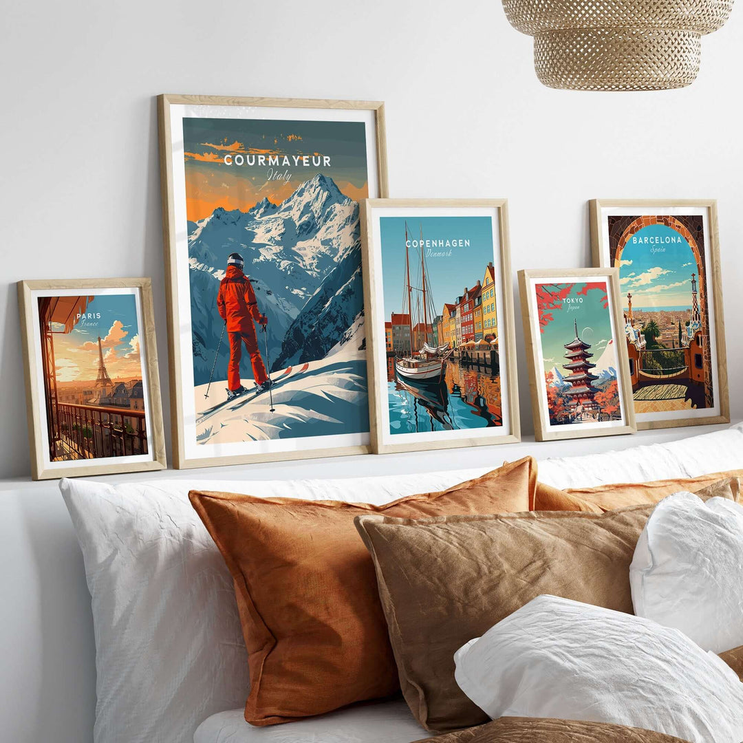 Collection of framed travel posters featuring Courmayeur ski scene, Copenhagen, Barcelona, and various landscapes on a couch.