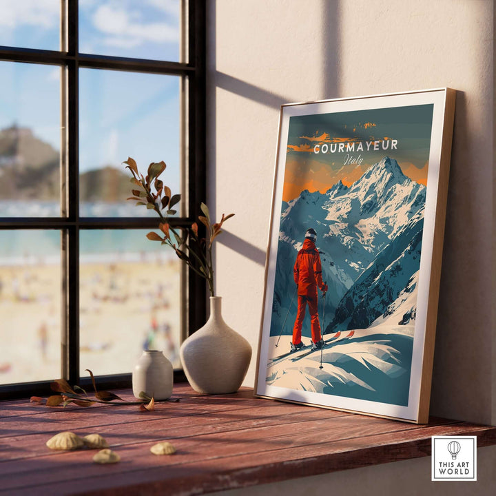 Vintage-style Courmayeur ski poster in frame, featuring skier and Italian Alps, displayed by sunny window on wooden shelf.