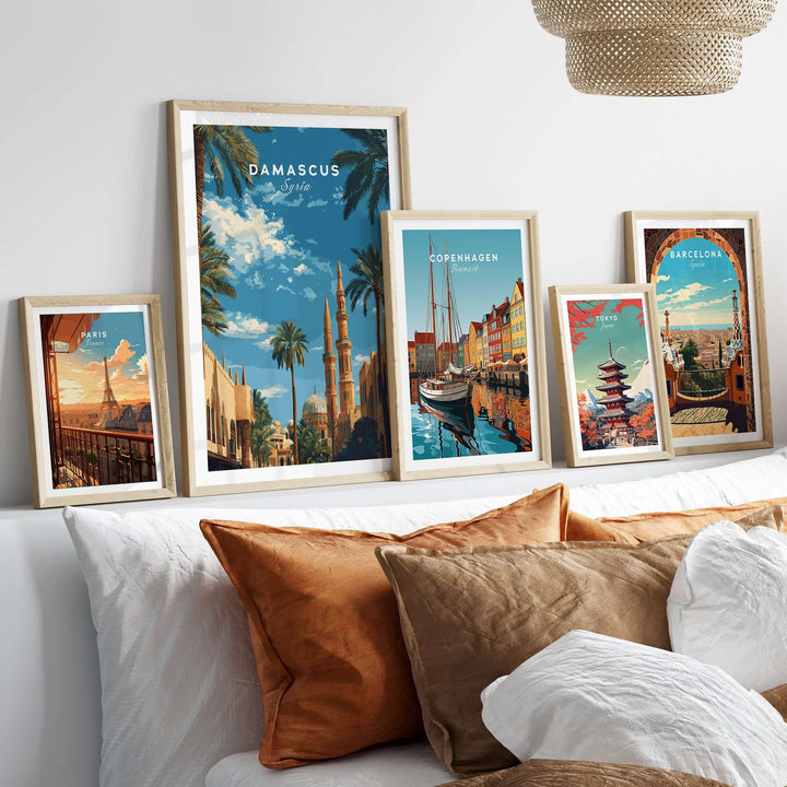 Collection of city travel posters including Damascus, Copenhagen, and Barcelona displayed on a sofa.