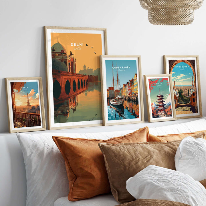 Framed travel prints featuring Delhi's Humayun's Tomb, Copenhagen, and Barcelona on a stylish bed backdrop.