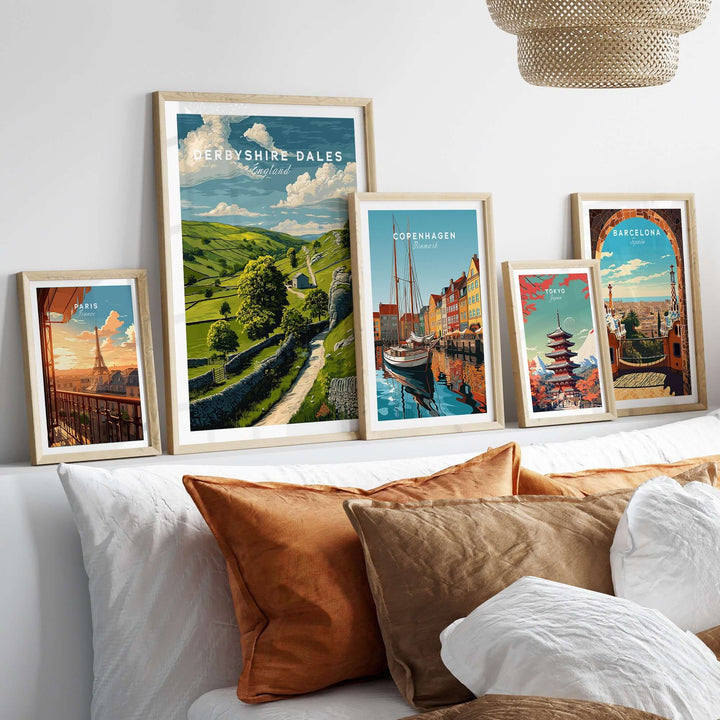 Gallery of travel posters featuring Derbyshire Dales, Copenhagen, and Barcelona above a cozy sofa.