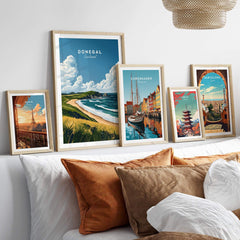Donegal Travel Print and other city travel prints displayed in stylish frames above a cozy bed.