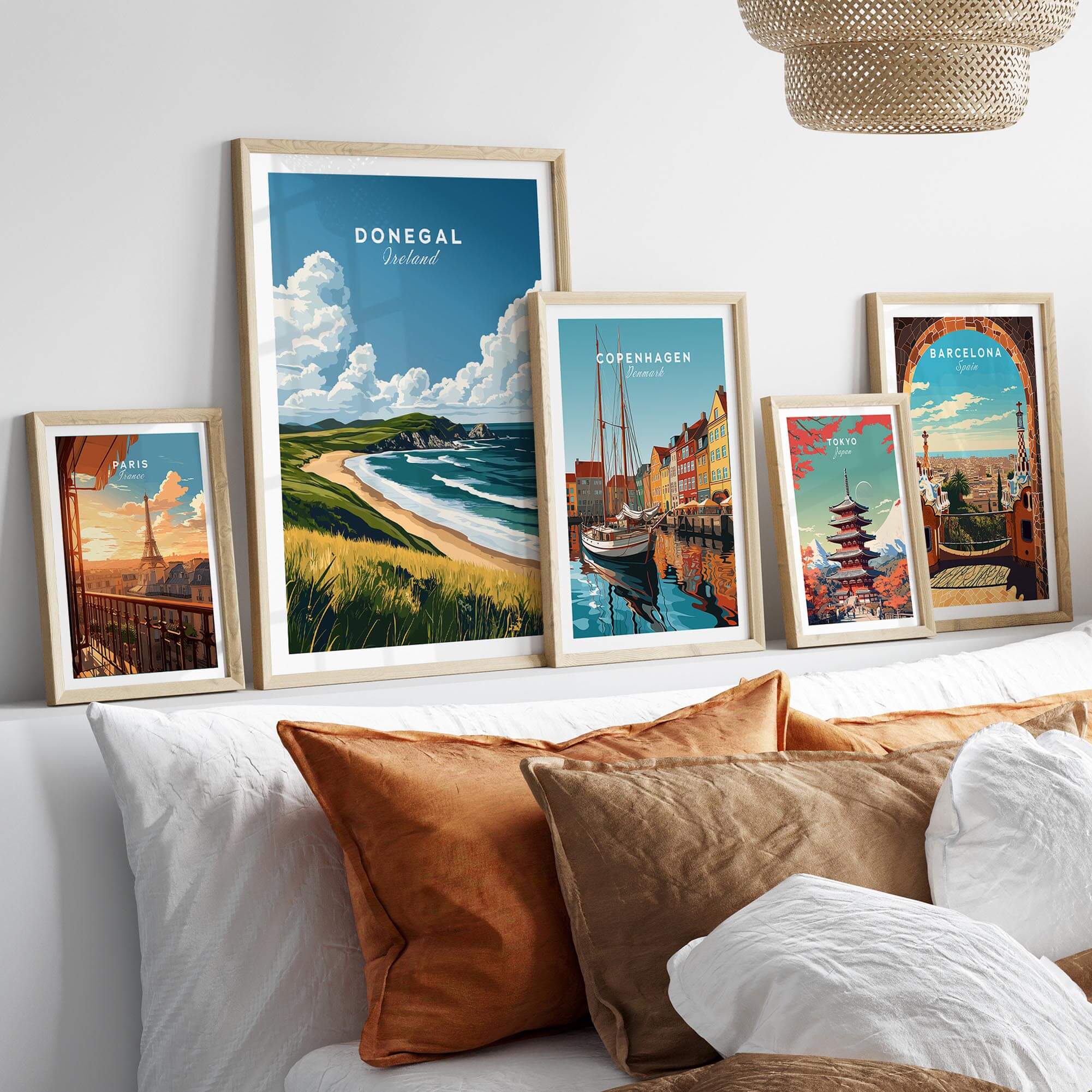 Donegal Travel Print and other city travel prints displayed in stylish frames above a cozy bed.
