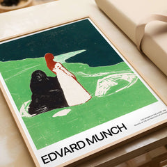 Edvard Munch Art Print - Two Women on the Shore 1898 Woodcut AIC Poster framed image on a wooden table.
