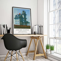 Edward Hopper House by the Railroad 1925 MoMA Art Print Poster displayed on a desk in a modern interior.