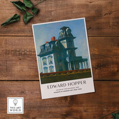 Edward Hopper House by the Railroad 1925 MoMA Art Print Poster on a wooden table.