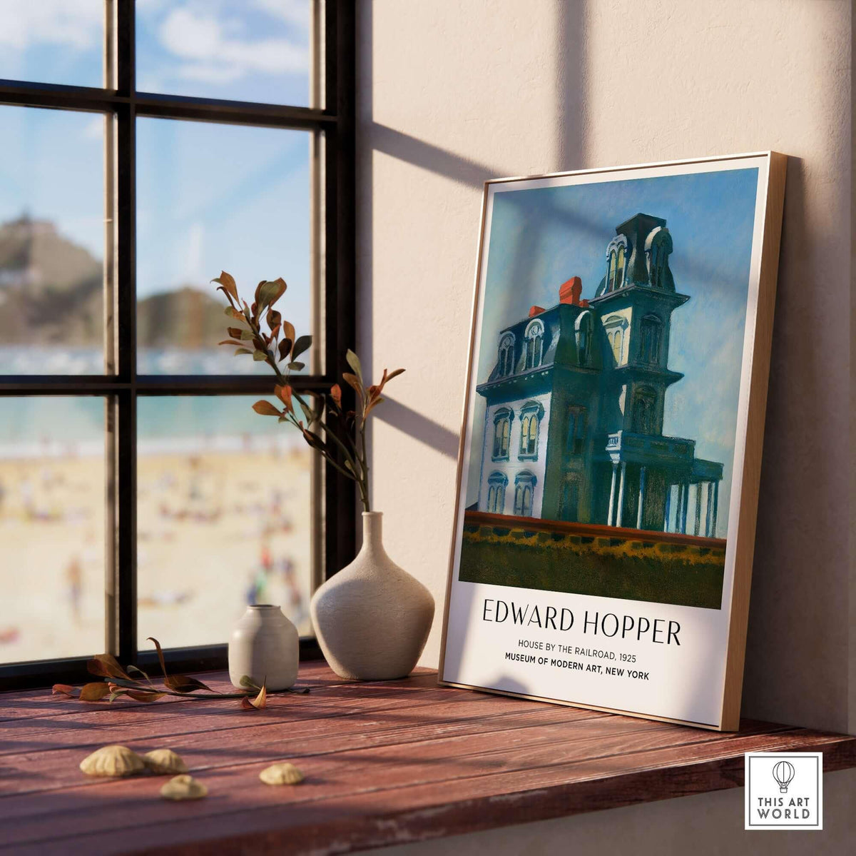 Edward Hopper House by the Railroad 1925 MoMA Art Print Poster displayed on a table near a window.