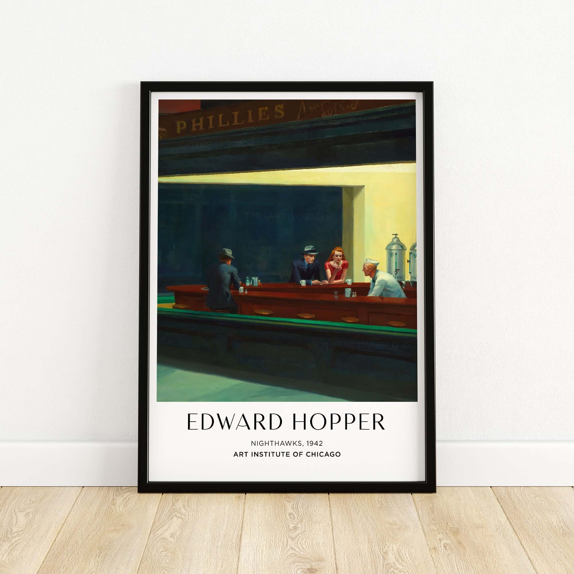 Edward Hopper Nighthawks 1942 Iconic Diner Art Print AIC Poster displayed in a frame on a wooden floor.