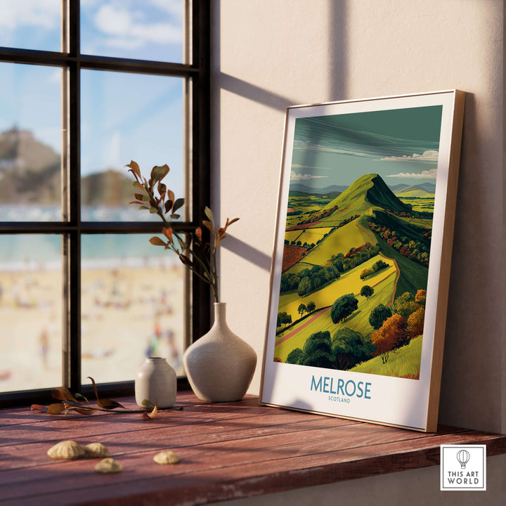 Eildon Hills travel print displayed by a window, showcasing Melrose landscape in vibrant colors.