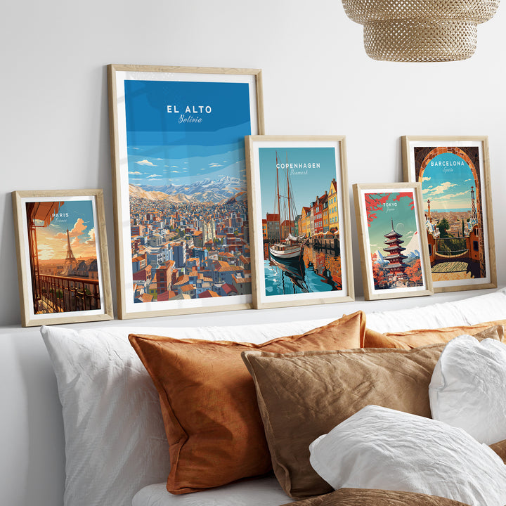 Framed El Alto Bolivia panoramic city art print among various city posters on a styled bed with decorative pillows.