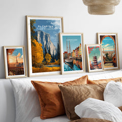 El Capitan Travel Poster – Yosemite National Park Granite Monolith Art framed among travel posters on a couch.