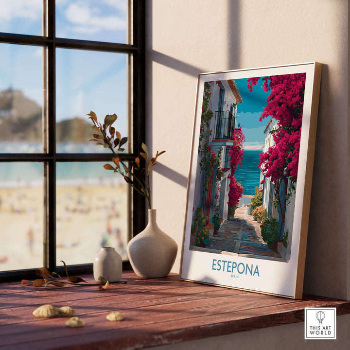 Estepona Spain Art Print | Bougainvillea Coastal Poster displayed on a wooden table by a window with a beach view.
