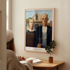 Exhibition Art Print American Gothic Grant Wood Famous Painting Wall Art Poster displayed above a person at a desk.