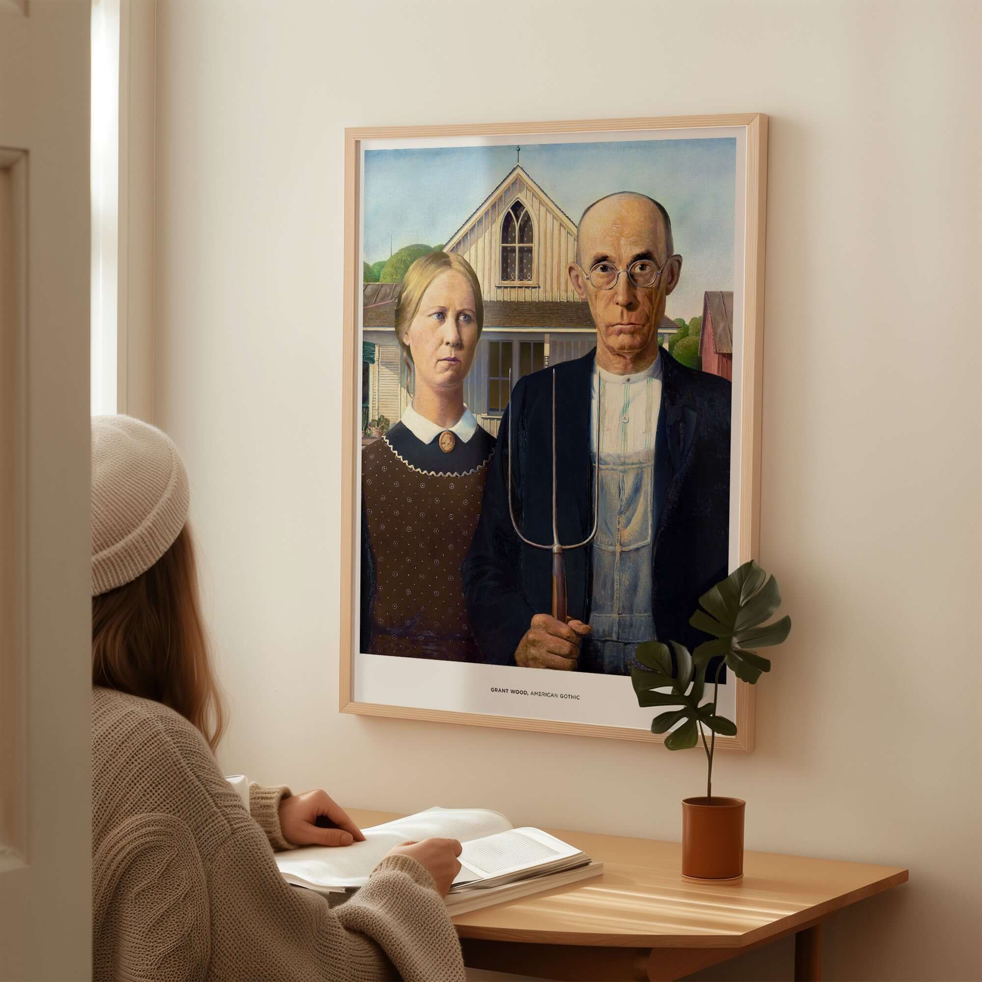 Exhibition Art Print American Gothic Grant Wood Famous Painting Wall Art Poster displayed above a person at a desk.