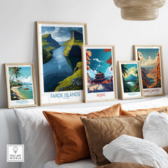 Faroe Islands Fjord Landscape Art Print displayed among various framed travel posters on a cozy sofa.