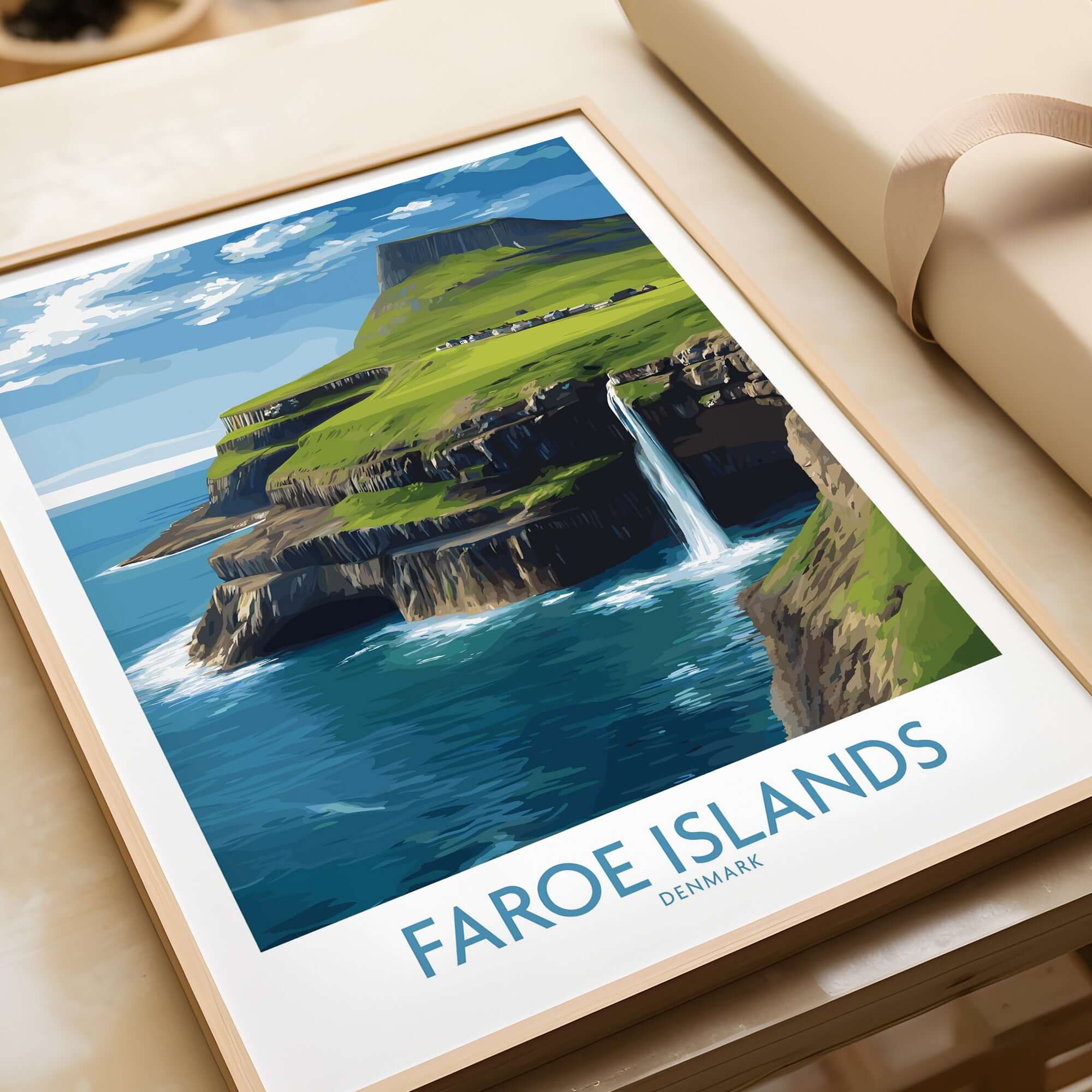 Faroe Islands Waterfall Art Print | Denmark Poster displayed on a table with a natural landscape background.