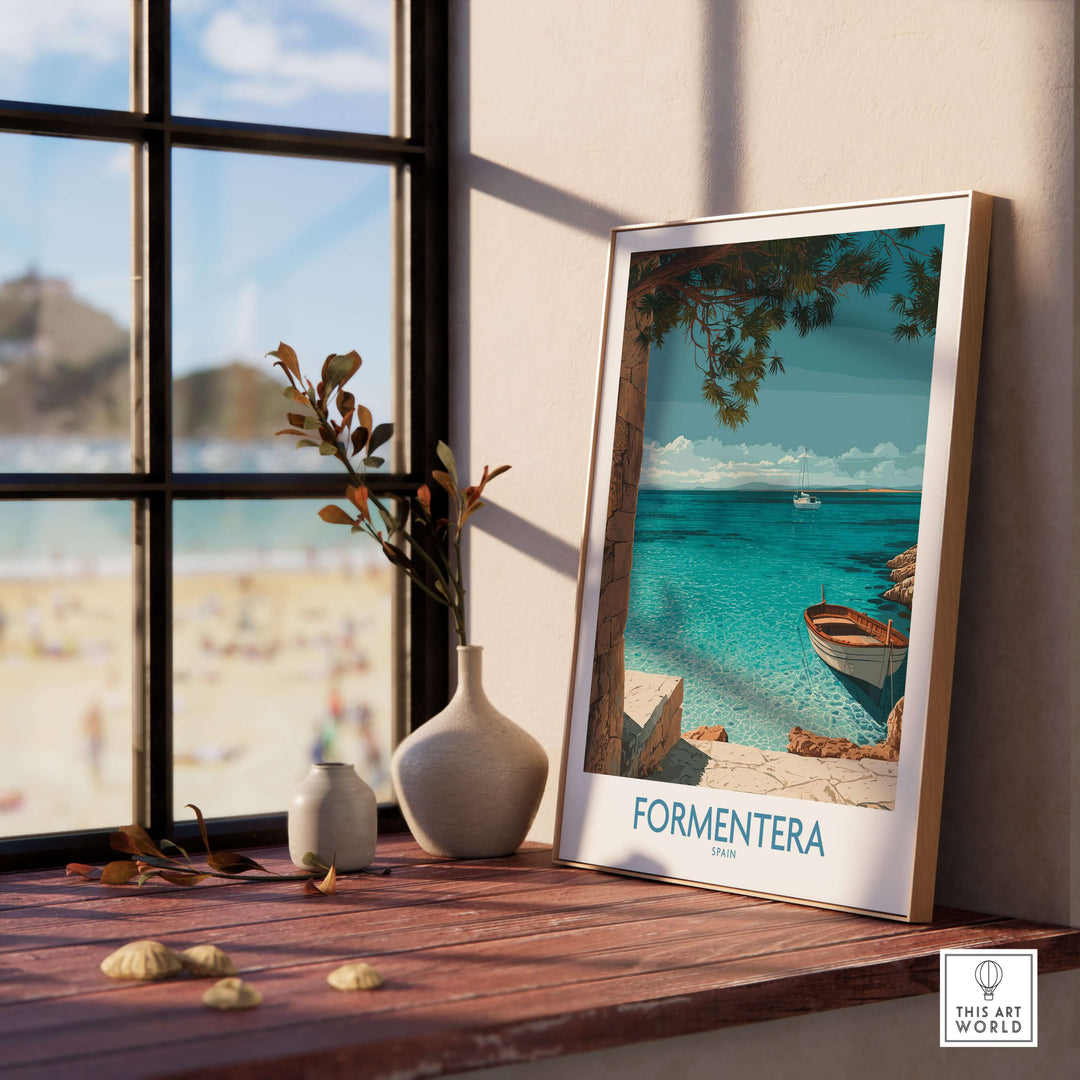 Formentera Spain Art Print | Beach Poster displayed on a table with a view of the beach through a window.