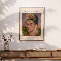Frida Kahlo Self Portrait Dedicated Dr Eloesser Floral Poster Art Print displayed on a wall above a wooden console.