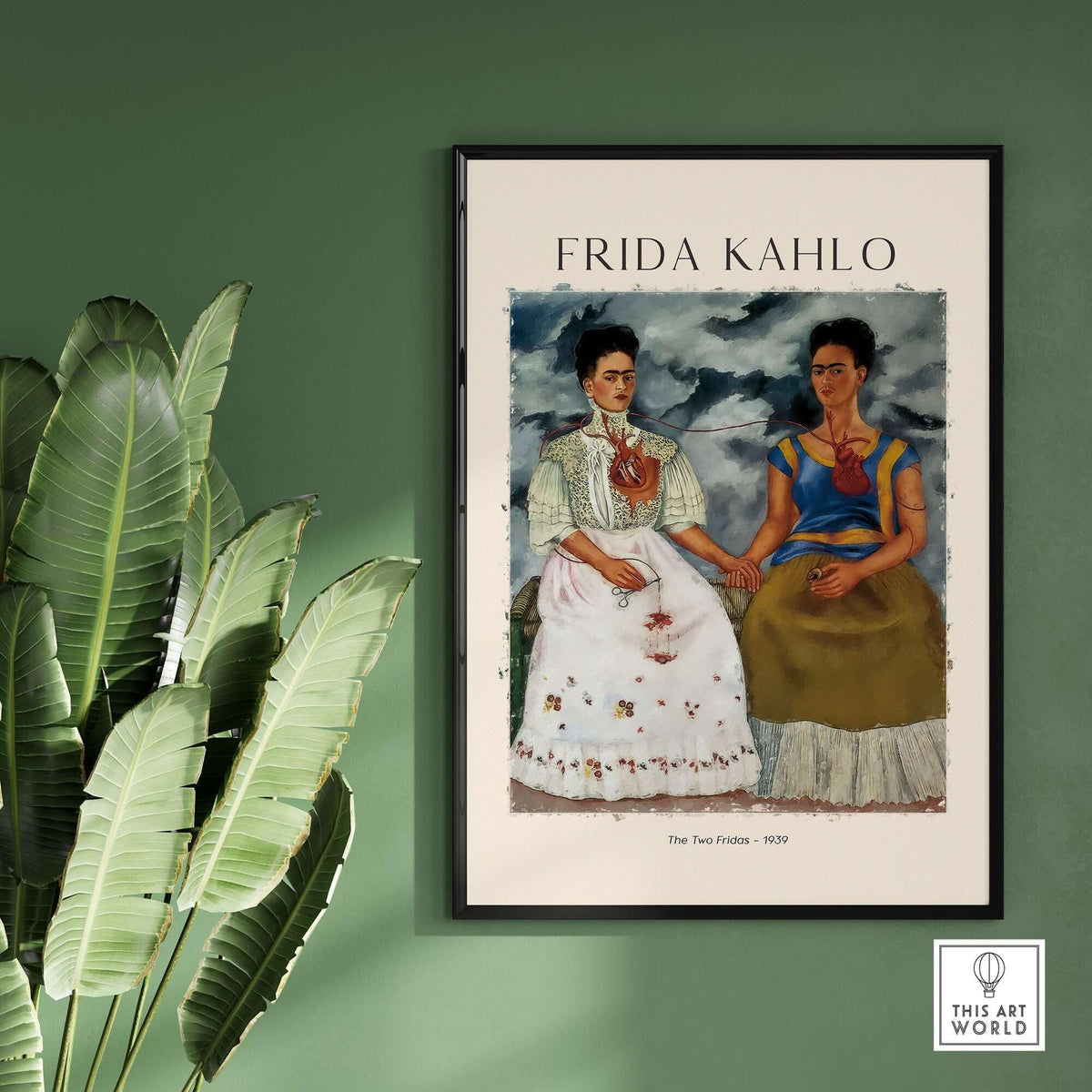 Frida Kahlo The Two Fridas Famous Art Print Poster Wall Art displayed in a frame on a green wall with plants.
