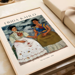 Frida Kahlo The Two Fridas Famous Art Print Poster Wall Art displayed on a table, showcasing the double self-portrait.