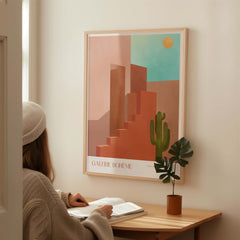 Galerie Bohème Abstract Moroccan Stairs Cactus Poster Desert Wall Art Print displayed above a woman studying at a desk.