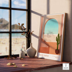 Galerie Bohème Moroccan Archway Cactus Art Print Terracotta Wall Decor Poster displayed on a windowsill.