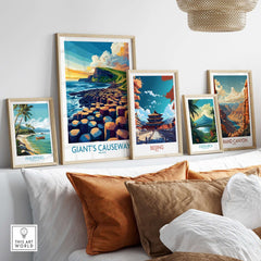 Giant's Causeway Travel Poster framed among other travel posters on a stylish couch in a modern living space.